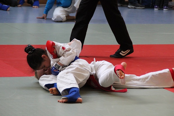 Oula Al Samman (blau) hält ihre Gegnerin in einem Haltegriff
